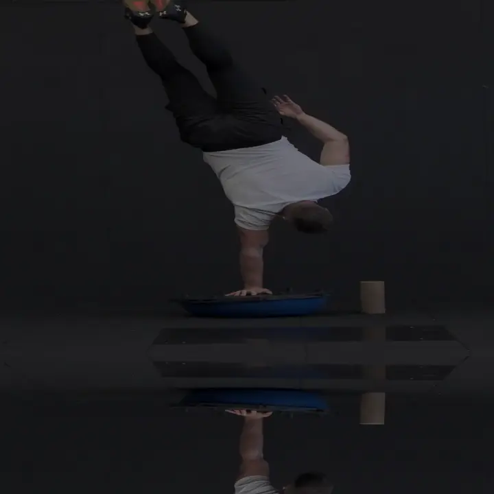 Marius Praniauskas holding a one-arm handstand on a balance dome