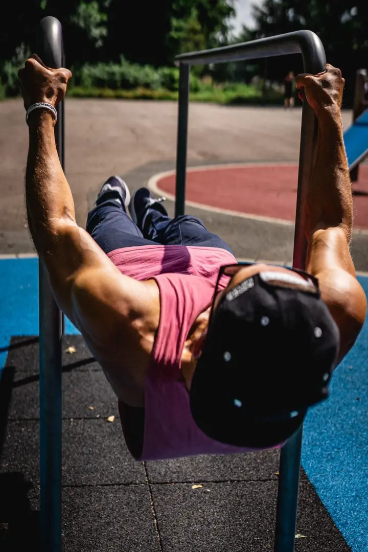 Man holding a front lever between two bars, seen from the head end