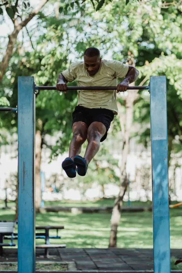 Man pressing out the top of a muscle-up on an outdoor bar