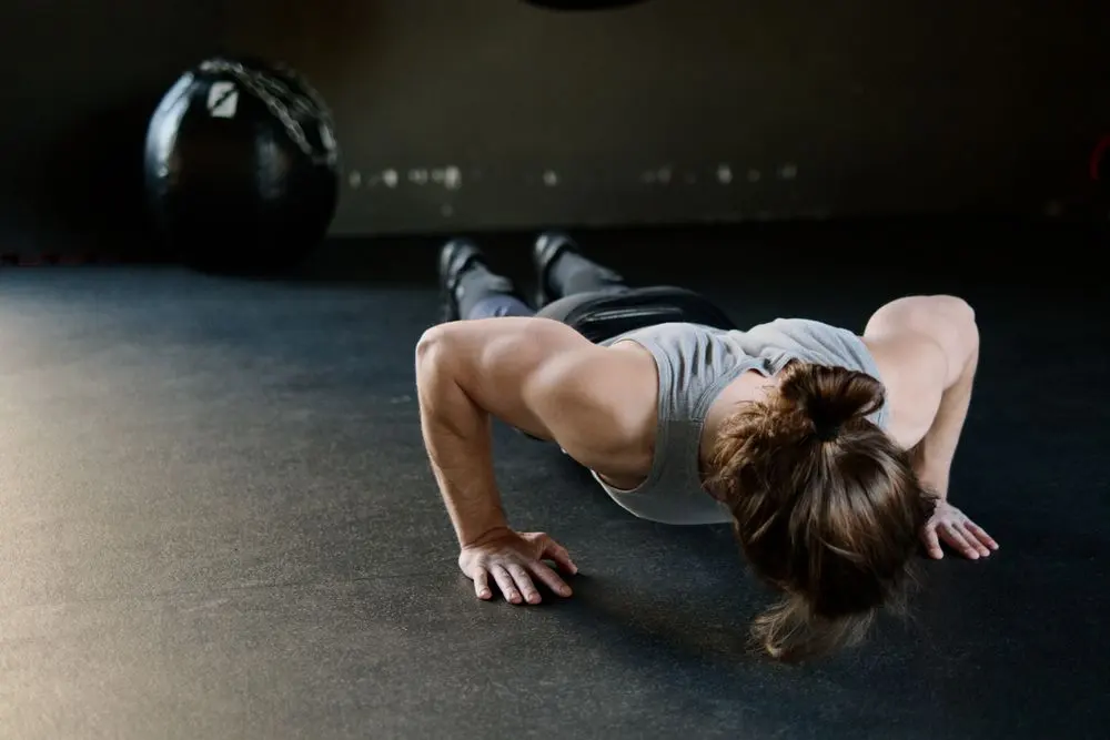 Man at the bottom of a push-up on a gym floor